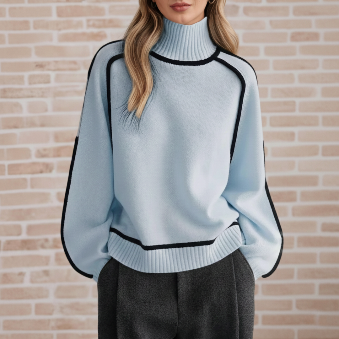 White women wearing a Blue refined knit turtleneck sweater from the Dylan Archer women’s premium clothing collection, styled in an elegant chic style with tailored trousers in a clean studio setting.